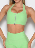close up front profile view of a model wearing the Power Zip Tank bra in electric green color
