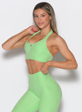 front left side profile view of a model wearing the Power Zip Tank bra in electric green color