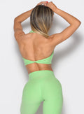back profile view of a model wearing the Power Zip Tank bra in electric green color