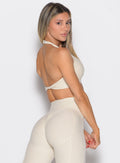 right side profile view of a model looking over her shoulder wearing the Power Zip Tank bra in pearl white color