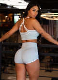 back profile view of a model in indoors wearing the Power Line Bra in cool arctic color paired with the matching shorts
