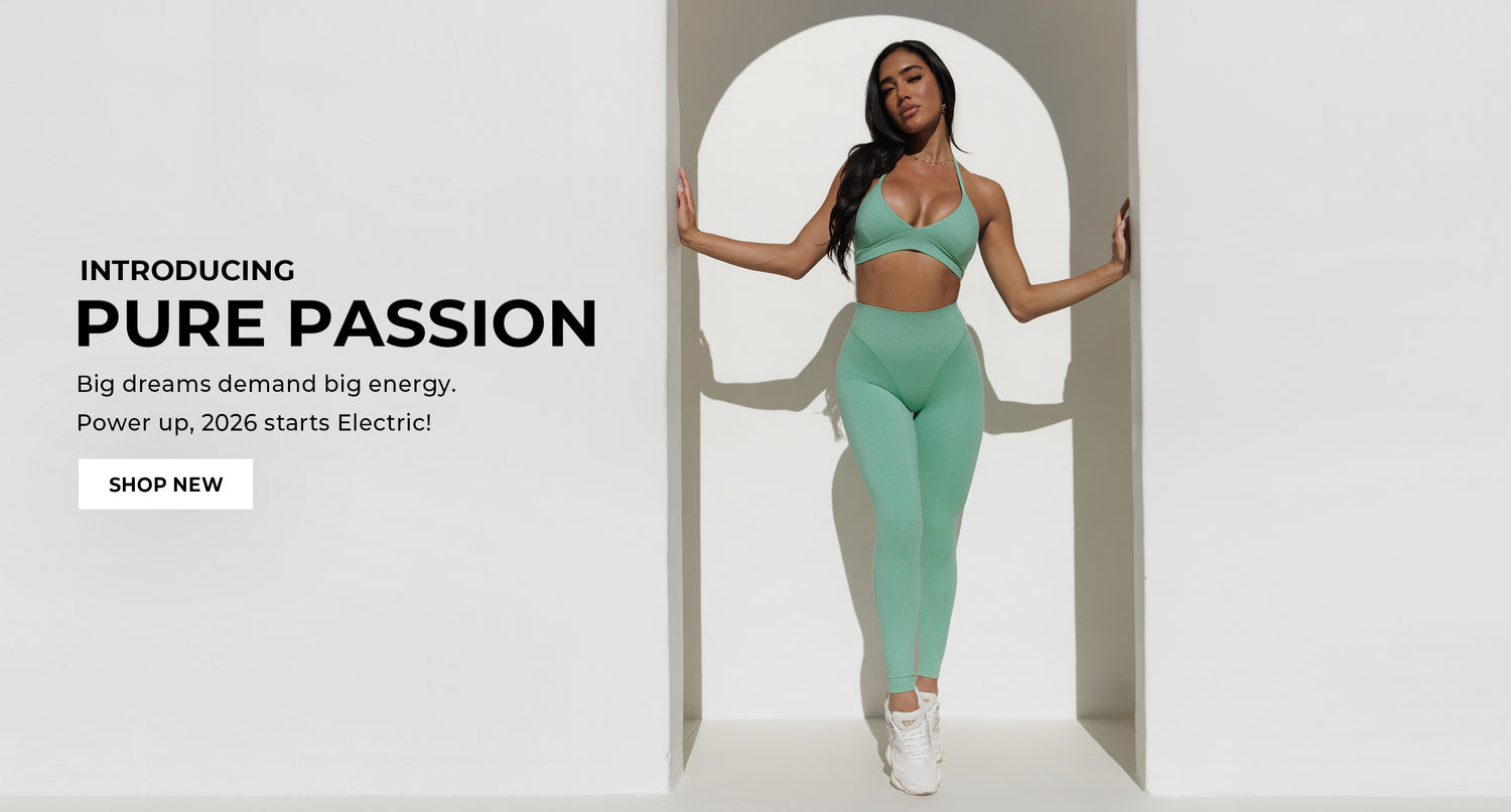 Woman in Sage (green) Hardbody Leggings and matching Electric Era Bra standing in an archway with promotional text for 'Pure Passion'. Text reads "Introducing PURE PASSION Big dreams demand big energy. Power up, 2026 starts Electric!" White call to action reads "Shop New"