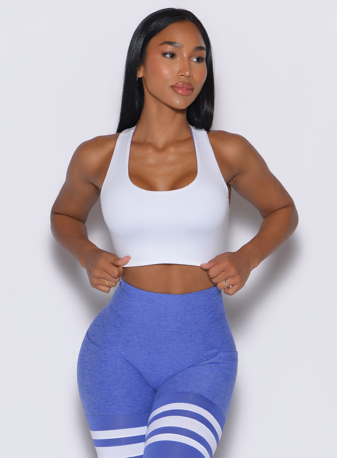 front profile view of a model wearing our white reversible tank bra along with a matching leggings 