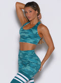 front left side profile view of a model wearing the Reversible Tank Bra in Teal camo