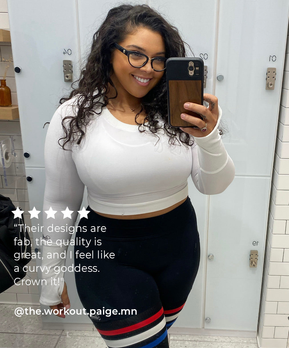 Girl taking a selfie wearing a white long sleeve top and black leggings