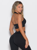 back right side profile view of a model looking over her shoulder wearing the Rib Backless Bra in black color