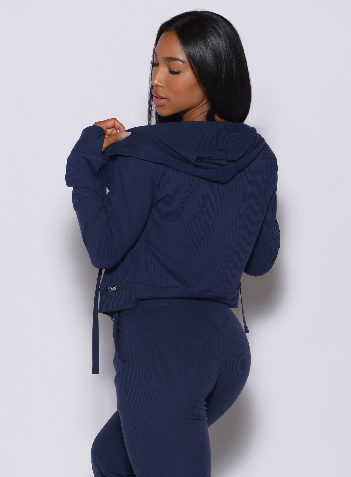back profile view of a model in our comfort rib jacket in navy and a matching leggings