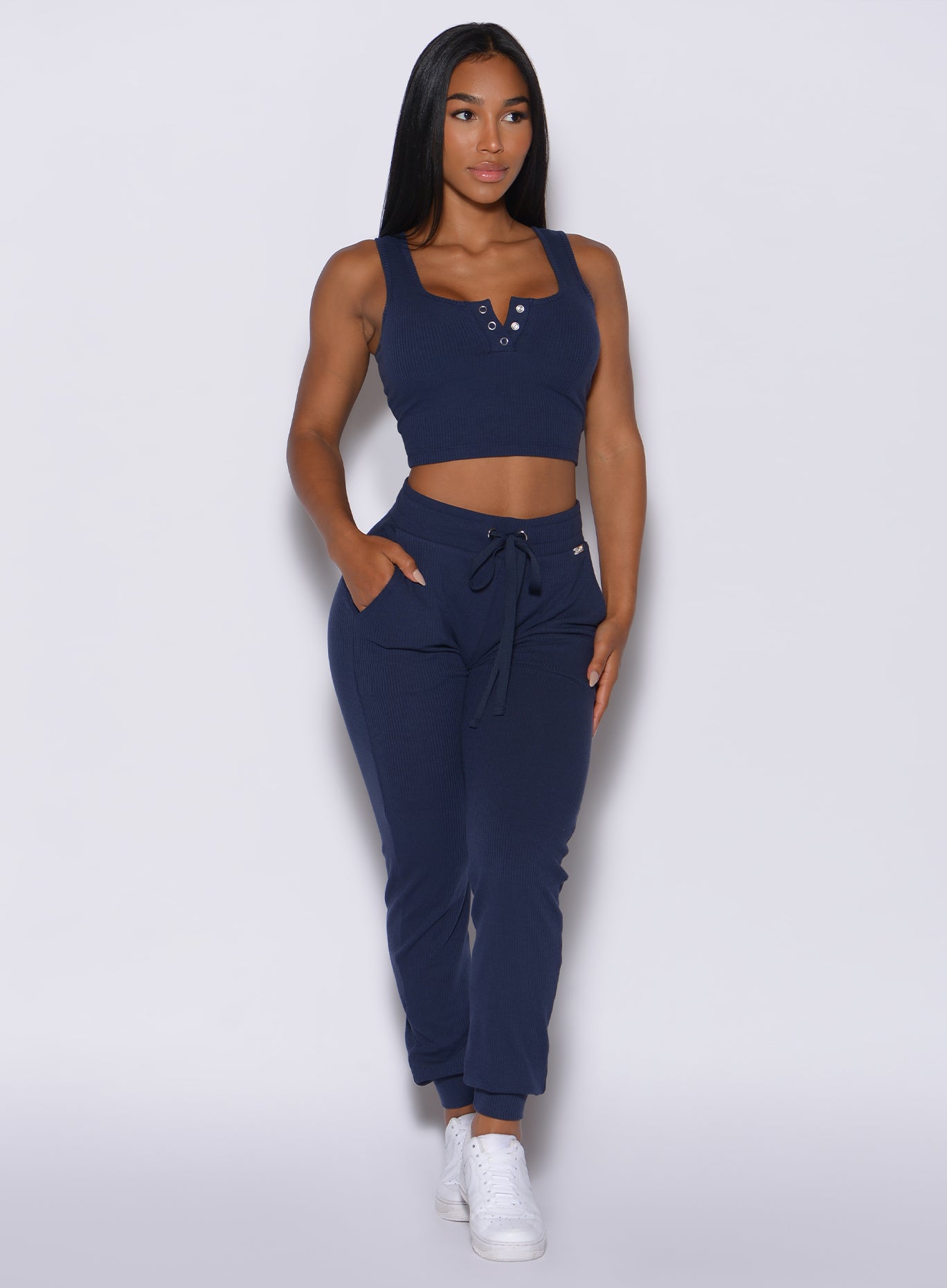 front profile view of a model in our comfort rib joggers in navy and a matching bra 