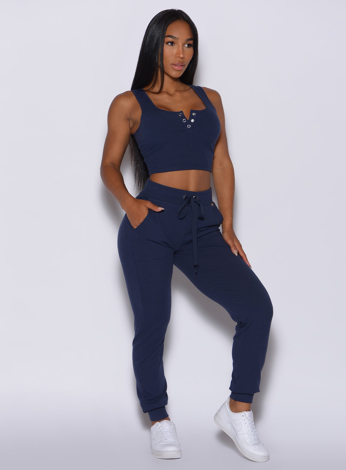 front profile view of a model angled slightly to her left wearing our comfort rib joggers in navy and a matching bra