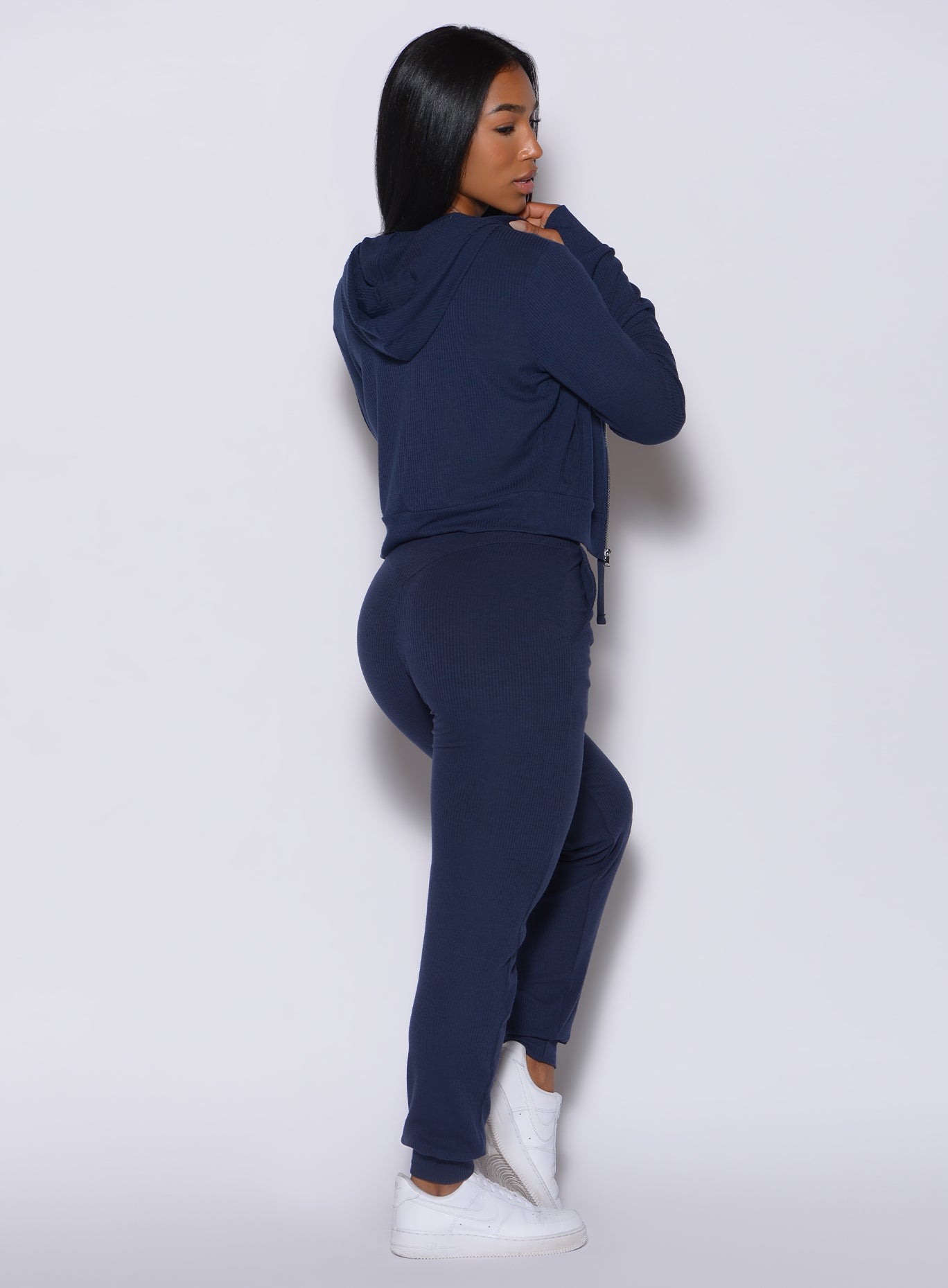 back profile view of a model in our comfort rib joggers in navy and a matching bra