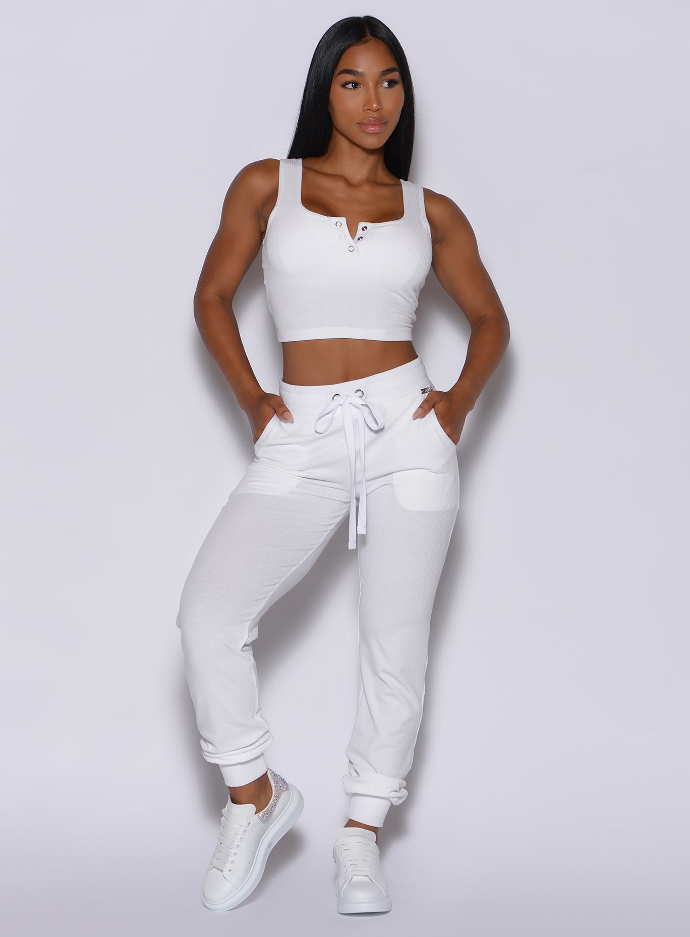 front profile view of a model with her hands in pocket wearing our white comfort rib joggers and a matching bra