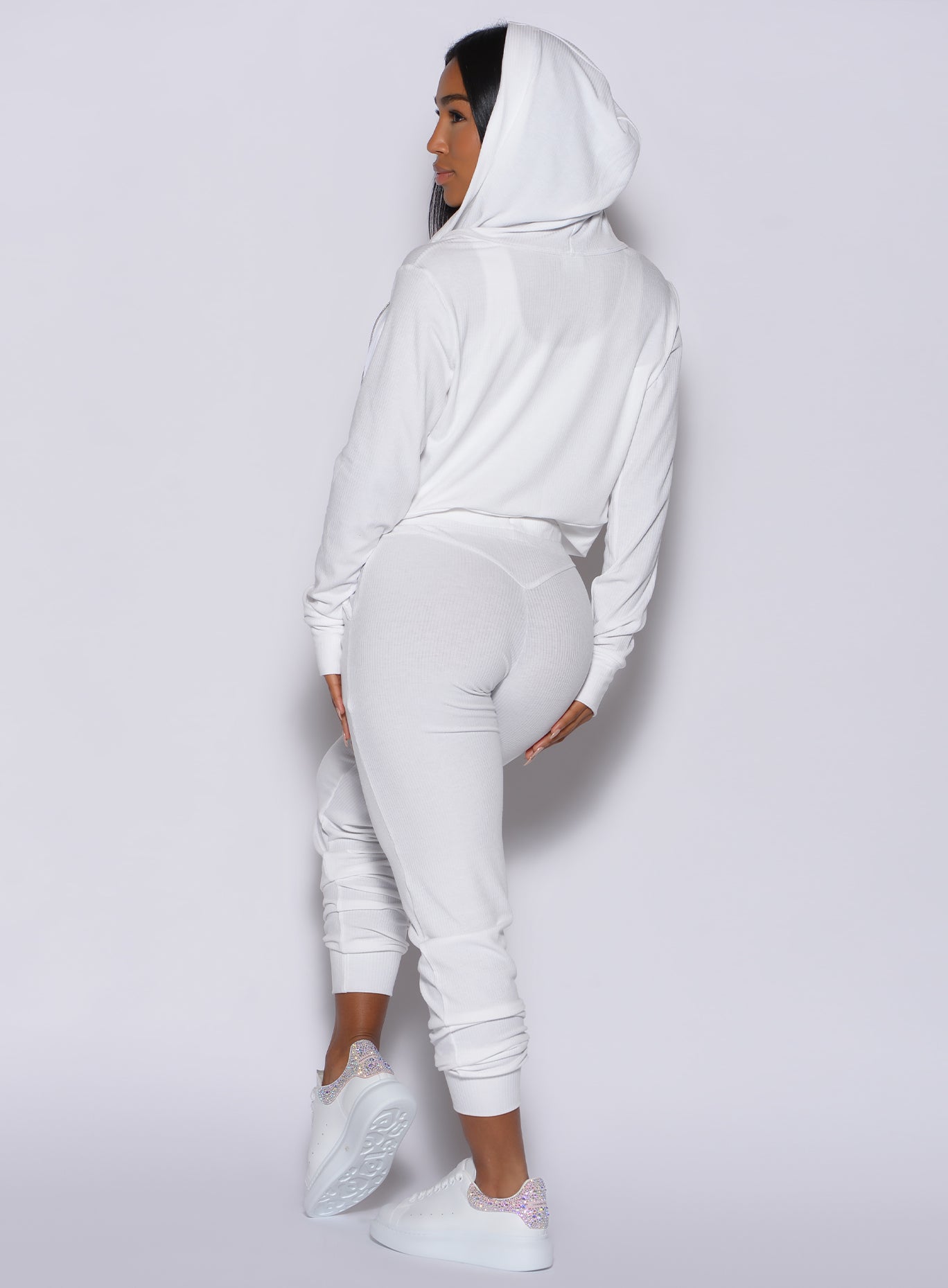 Back profile view of a model wearing our white comfort rib joggers and a matching white jacket