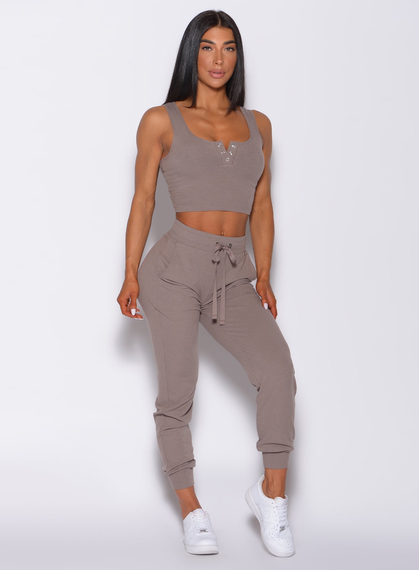 Front profile view of a model in our comfort rib joggers in toffee color and a matching bra