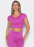 Woman wearing a bright purple athletic outfit on a white background