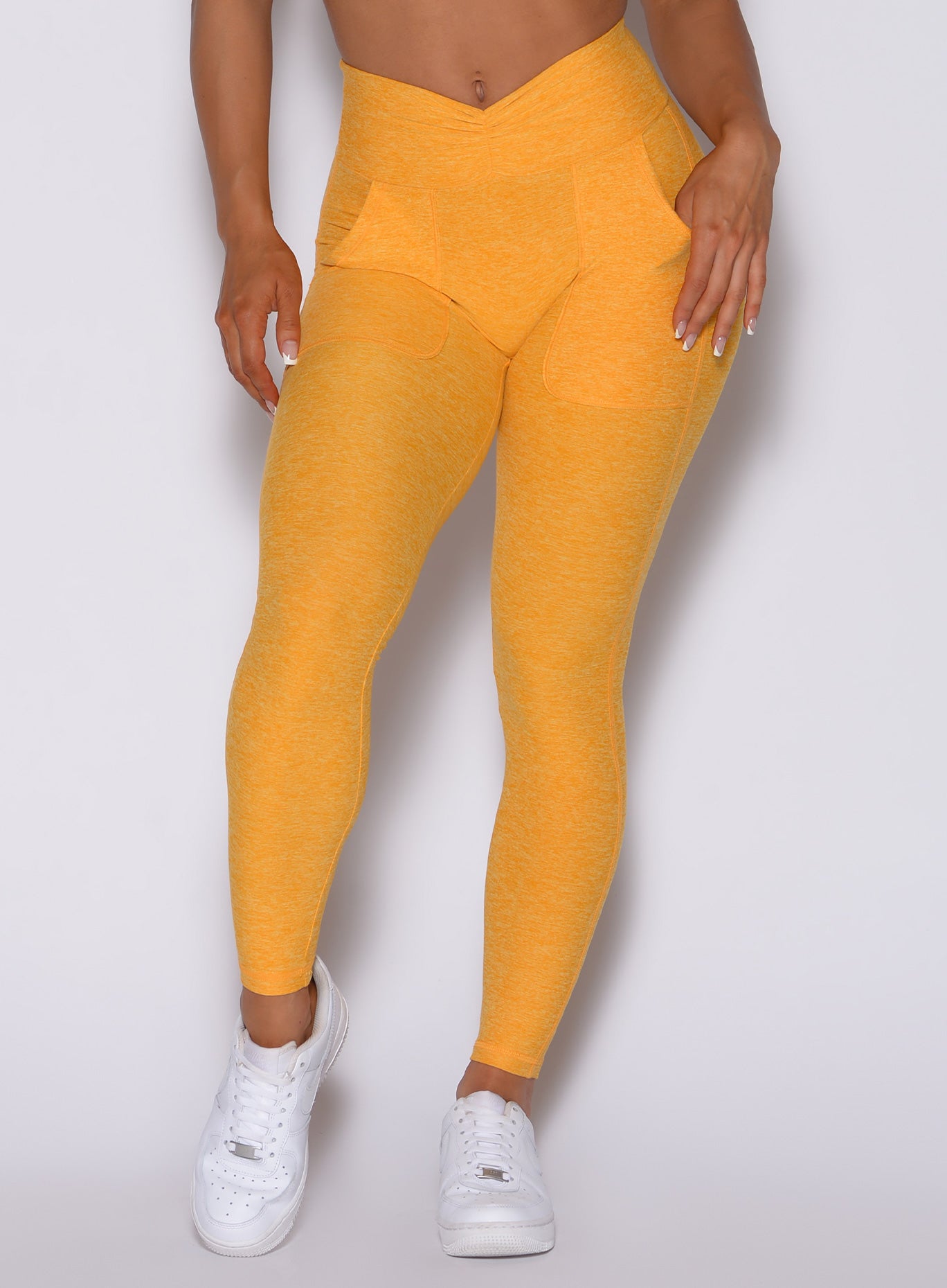 zoomed in front profile view of our V scrunch leggings in sunkissed color 