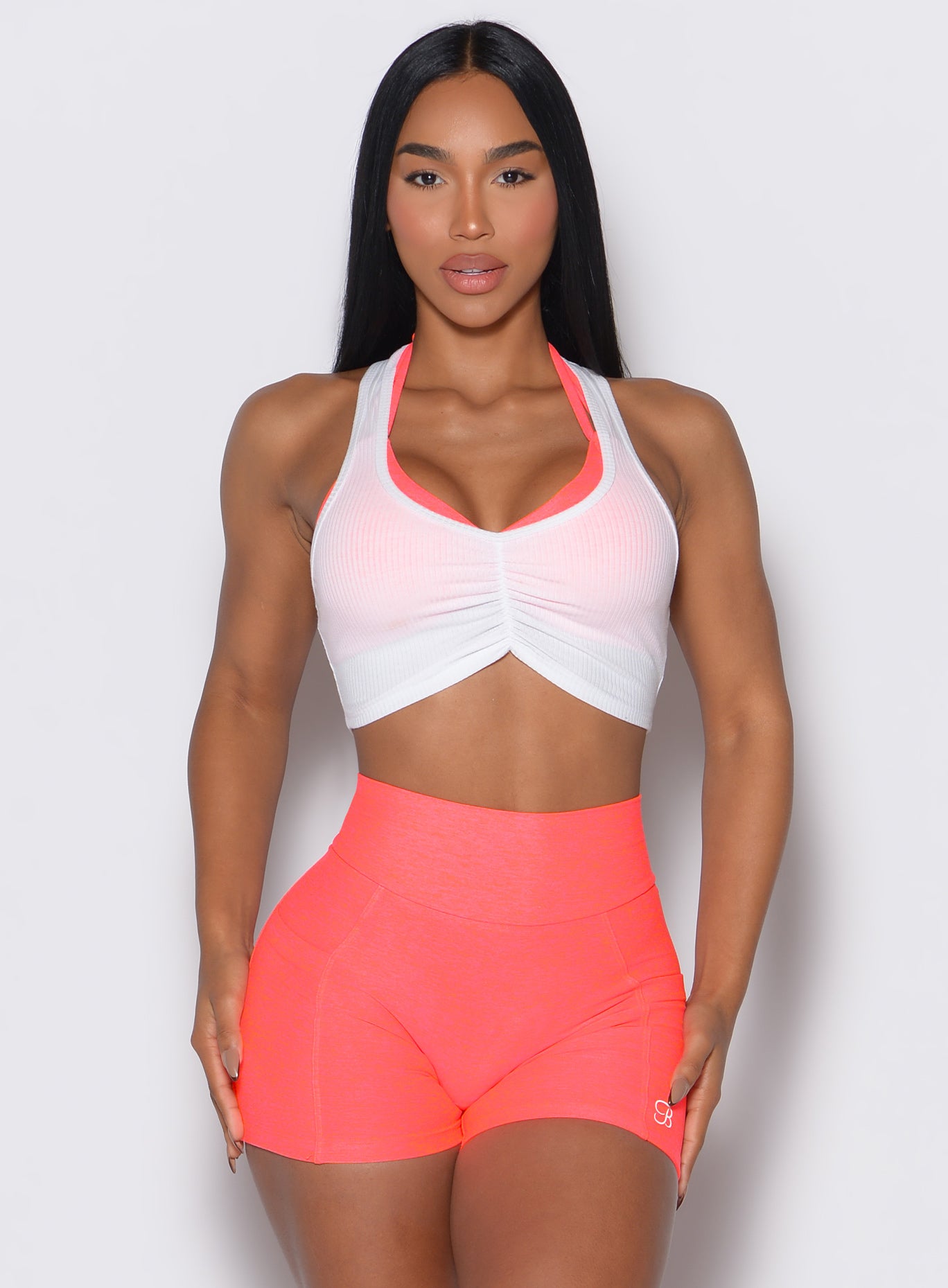 model facing forward wearing our white Butterfly Rib Tank on the top of a pink sports bra