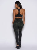 back side profile view of a model facing to the left side wearing the Scrunch Thigh Highs in Green/Black camo color