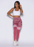 frontal view of a model with one hand on her waist wearing the Scrunch Thigh Highs in Hibiscus camo color