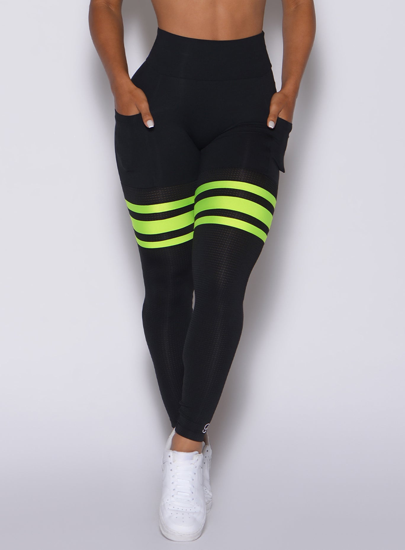 Zoomed in front view of our black scrunch thigh highs with 3 neon yellow stripes on each thigh 