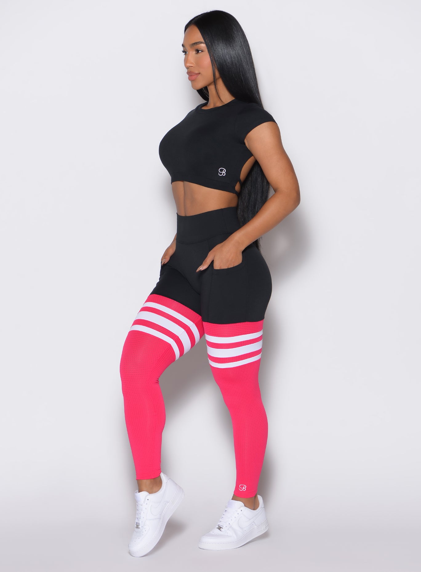Left profile view of a model wearing the Scrunch Thigh Highs in Black and Berry Color along with a black tee