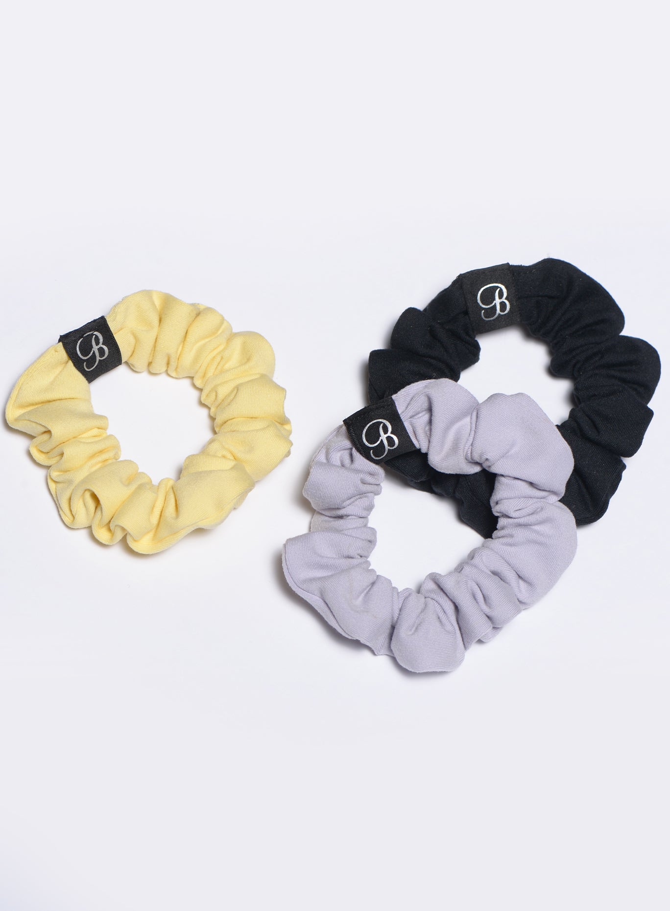 Diverse trio of soft fabric B Scrunchies; essential performance hair ties for intense training.