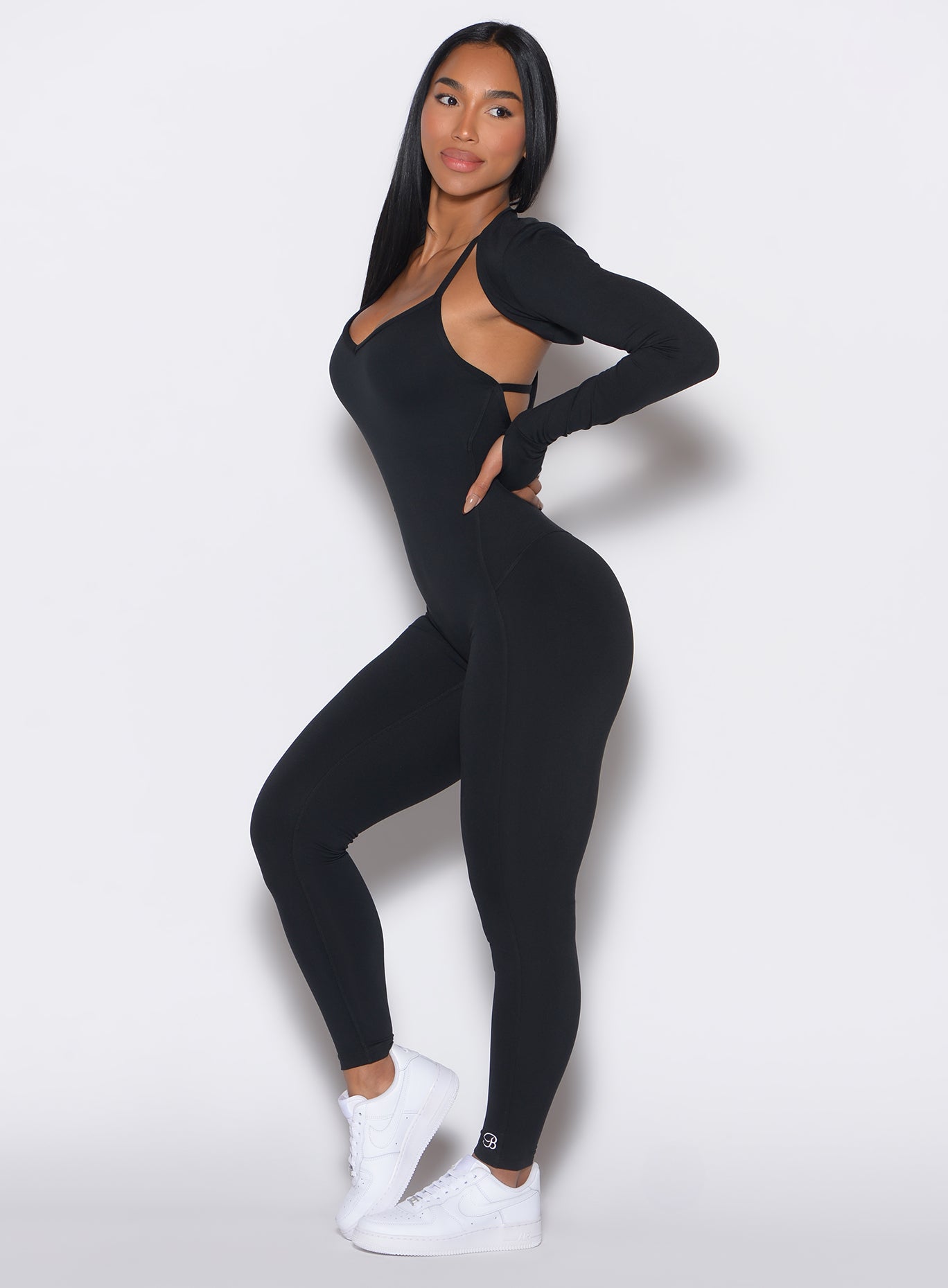 Black Shape Shrug layering piece with long sleeves and thumbholes for sculpting gym performance.