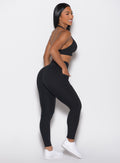 right side profile view of a model wearing the Sculpt Knot Leggings in black color