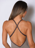 close up back profile view of a model wearing the Lift Bodysuit Shorts in Stone color