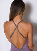 a close up back side view of a model wearing the Lift Bodysuit Shorts in Violet frost color