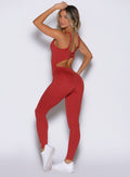 left side profile view of a model wearing the Sculptura Bodysuit in Sunrise red color