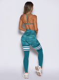 back side profile view of a model wearing the Scrunch Thigh Highs in Teal camo color