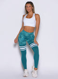 frontal view of a model wearing the Scrunch Thigh Highs in Teal camo color