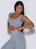 left side view of a model wearing our Snap Seamless Bra and the matching leggings in Carbon color