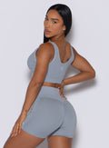 left side view of a model facing to her left wearing our Snap Seamless Bra and the matching shorts in Carbon color