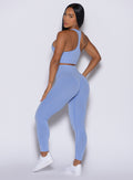 left side view of a model facing to her left wearing our Contour Seamless Leggings and the matching Lifter Heather Seamless Bra in Sky color