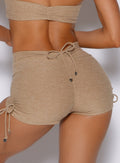 close up back profile view of a model wearing the Charm Fit shorts in sandstone color