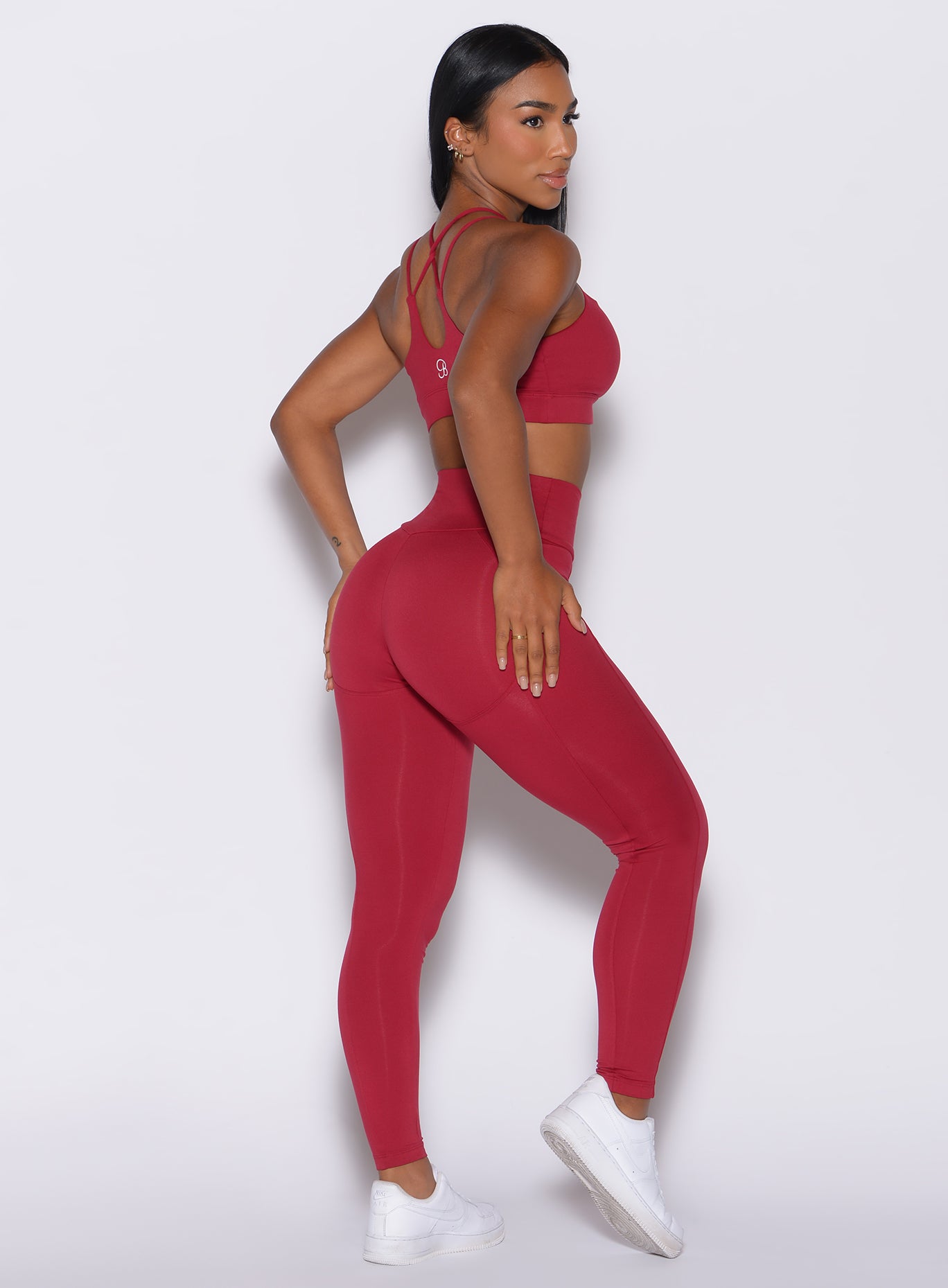 Right side profile view of a model facing to her right wearing our shape leggings in maroon color along with the matching bra