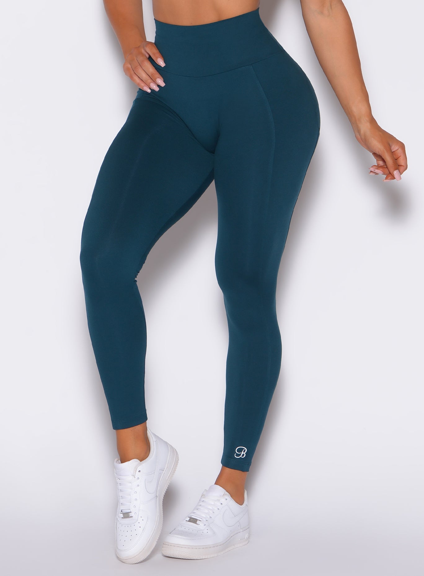 Zoomed in front view of our shape leggings in peacock color 
