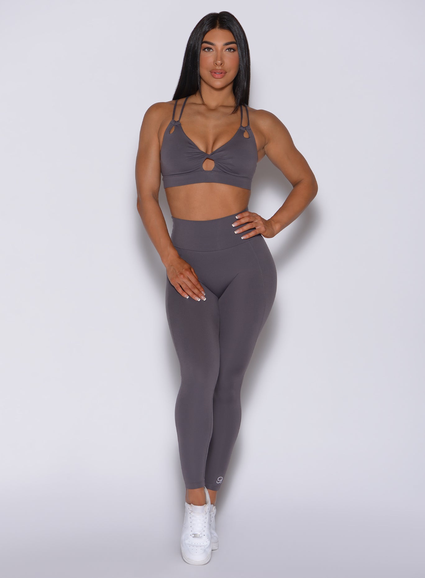Front profile view of a model in our new and enhanced shape leggings in gray smoke color and a matching bra