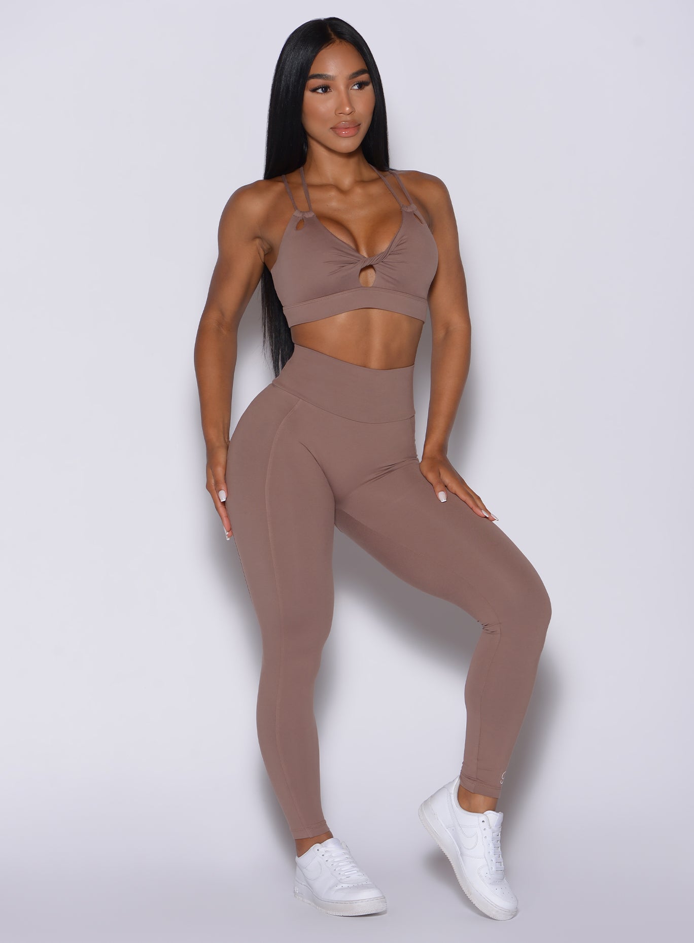 Front profile view of a model in our new and enhanced shape leggings in tan color and a matching bra