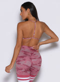 back profile view of a model facing to the left side wearing the She owns it Bra in hibiscus camo