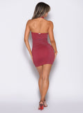 back profile view of a model facing right wearing the Shimmer Seamless Dress in Red hot star color