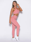 front right side profile view of a model looking to the back wearing the Shimmer V Back Leggings in Pink star color