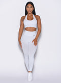front profile view of a model wearing the Shimmer V Back Leggings in White star color paired with the matching sports bra