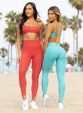 two models standing next to each other in outdoors wearing the Wave Wire Leggings in Crystal current color and fire storm color