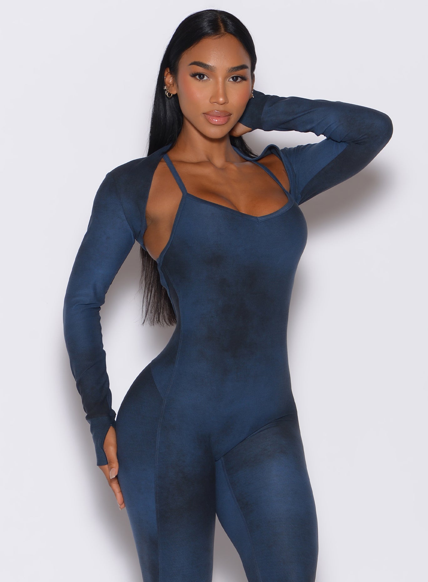 Front profile view of a model wearing our shape shrug in vintage blue color along with the matching bodysuit