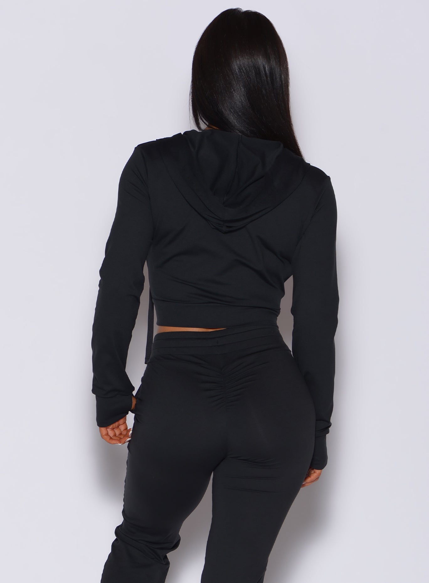Black Signature Jacket back view featuring a fitted hood and thumbholes for active performance.