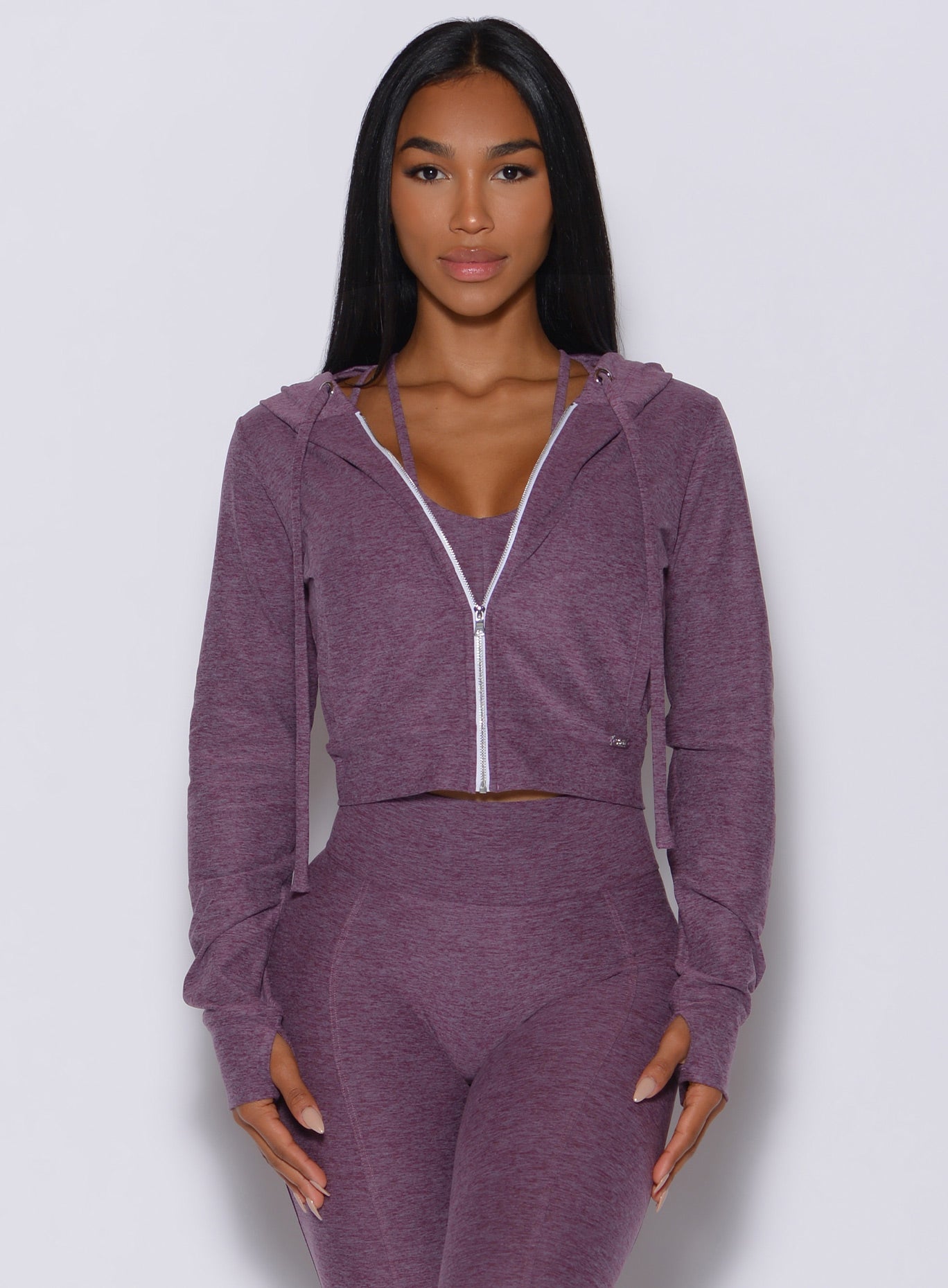 picture of a model model facing forward wearing our signature jacket in regal purple  along with a high waisted leggings 