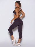 Rear-left angle capturing the contoured fit and high-performance feel of Black Orchid capris