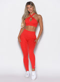 Model facing forward wearing our Smooth Leggings and the matching bra in Cherry Bomb color